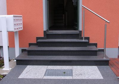 Treppenaufgang mit Geländer und Briefkasten